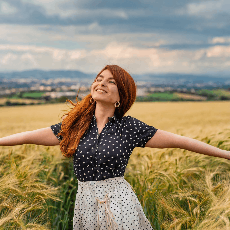 giovane_donna_con_capelli_rossi_che_apre_le_braccia_felice_mentre_e_in_un_campo_di_grano_78.png